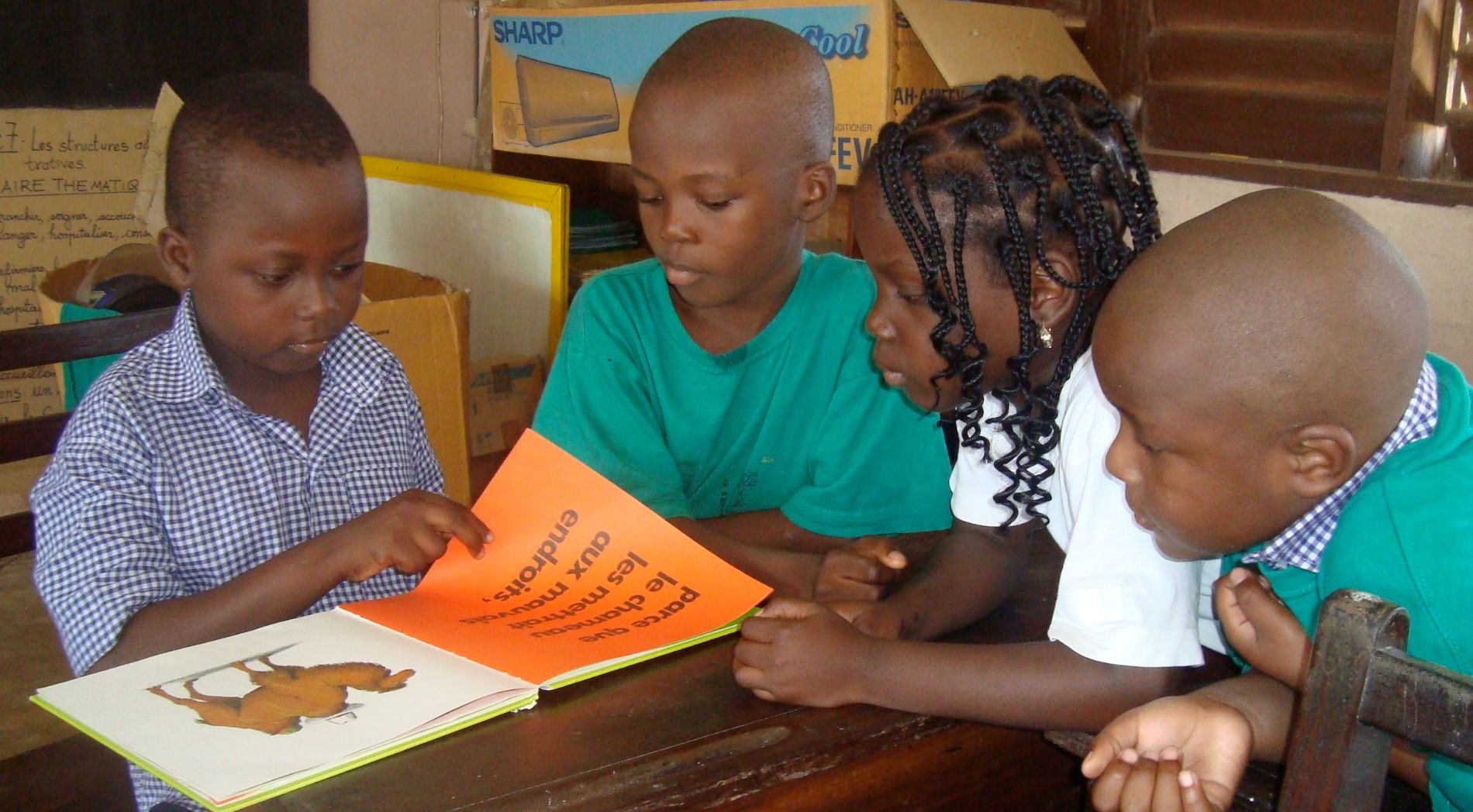 Des enfants partagent une lecture autour d’une table
