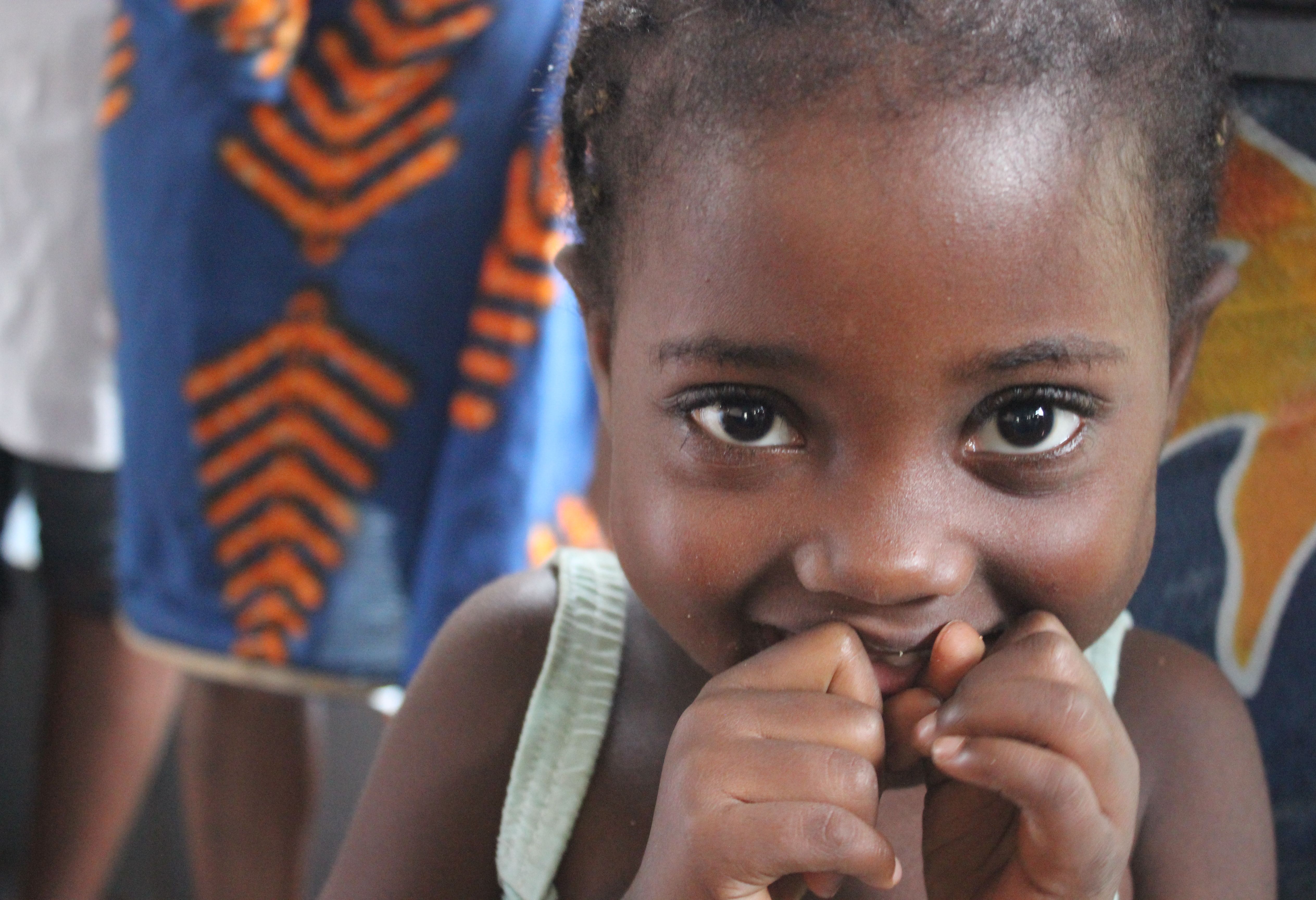 Portrait d’un enfant, les mains près du sourire